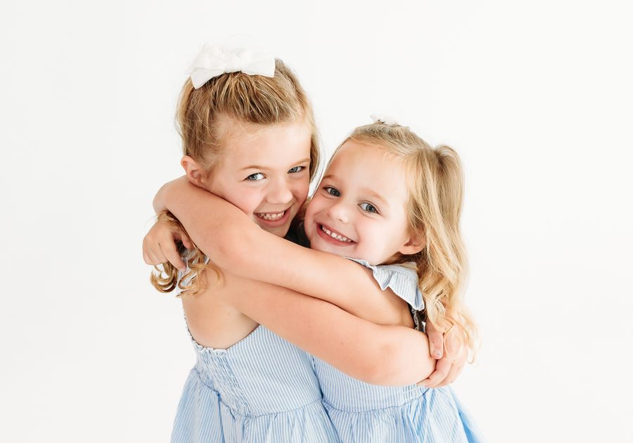 Two sisters hugging during a family session
