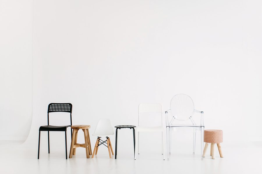 A row of studio chairs and stools against the white wall