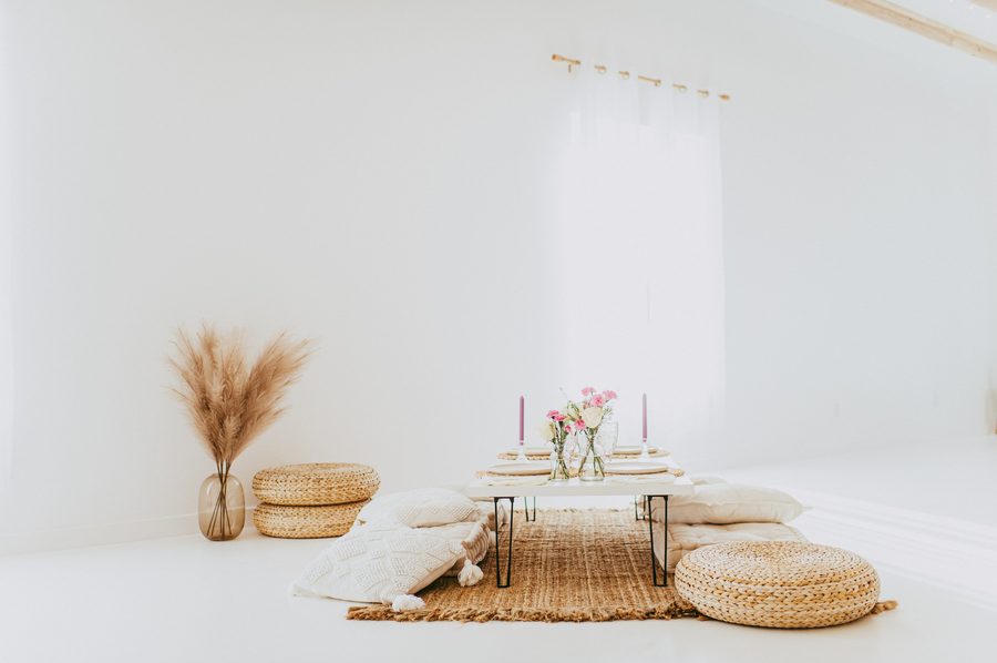 A low table with woven mats and pampas set for a gathering