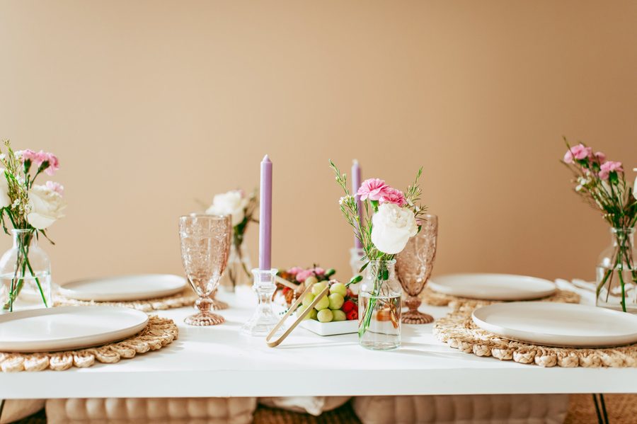 The painted side: a warm tan wall behind a set table with flowers and candles