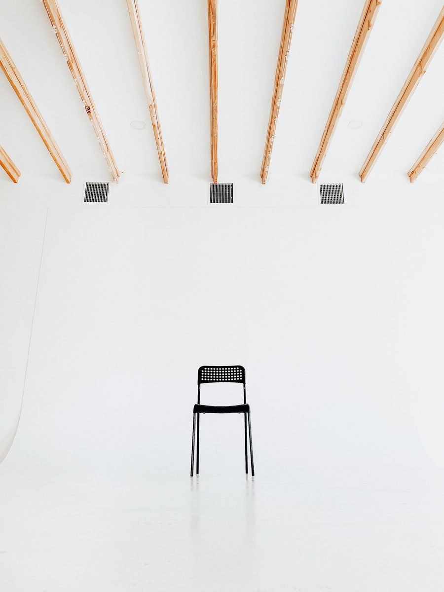A single black chair under the timber beams